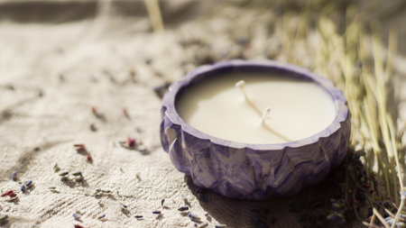 a white candle in a purple candlestickの写真素材