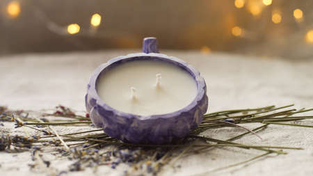 a white candle in a purple candlestickの写真素材