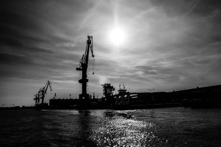 Gdansk shipyard, Poland. Retro style black and white. Cranes, old shipyard buildings, rusty structures.の写真素材