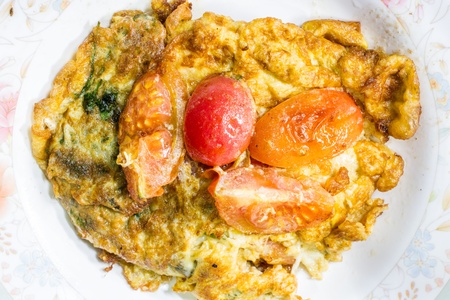 Fire egg with parsley and tomatoの写真素材