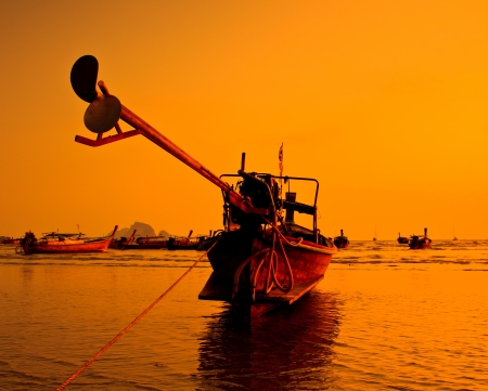 Silhouettes fishing boats at sea in sunset Krabi Province Thailandの写真素材
