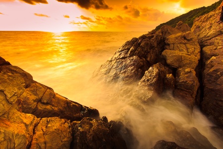Landscape sunset sea waves line impact rock on the beach の写真素材