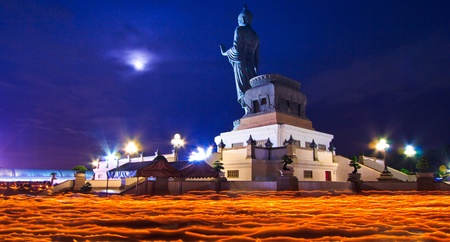 Buddha statue candle lit in lent day thailand and Walk with lighted candles in hand around a templeの写真素材