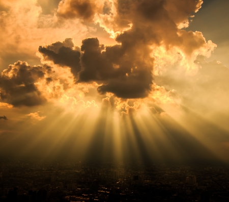 Rays of light shining through dark clouds for background の写真素材
