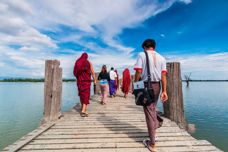 U Bein Bridge, Myanmar-Aug 26th, 2014: Myanmar monks walk on U Bein Bridge where is the oldest and longest teak wooden bridge in the world.のeditorial素材