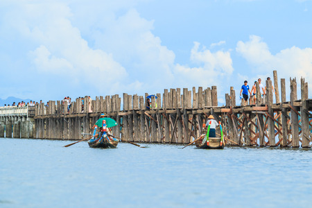 AMARAPURA, MYANMAR - Aug 26th, 2014: An unidentified man rows his boat on Aug 26th, 2014: in Amarapura, Myanmar. Amarapura is famed for the longest teak bridge in the world.のeditorial素材