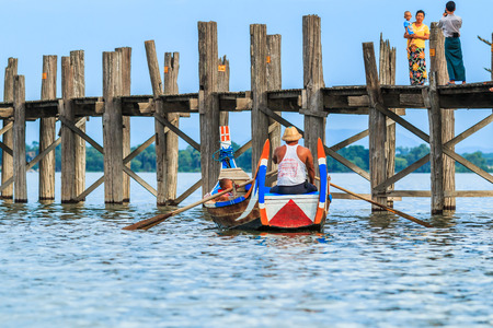 AMARAPURA, MYANMAR - Aug 26th, 2014: An unidentified man rows his boat on Aug 26th, 2014: in Amarapura, Myanmar. Amarapura is famed for the longest teak bridge in the world.のeditorial素材