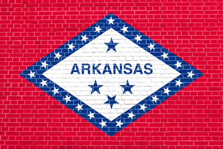 Arkansan official flag, symbol. American patriotic element. USA banner. United States of America background. Flag of the US state of Arkansas on brick wall texture backgroundの写真素材