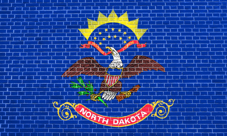 North Dakotan official flag, symbol. American patriotic element. USA banner. United States of America background. Flag of the US state of North Dakota on brick wall texture backgroundの写真素材