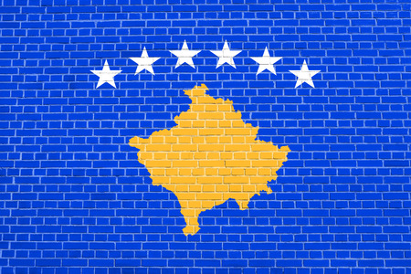Kosovan national official flag. Patriotic symbol, banner, element, background. Accurate dimensions. Correct size, colors. Flag of Kosovo on brick wall texture backgroundの写真素材