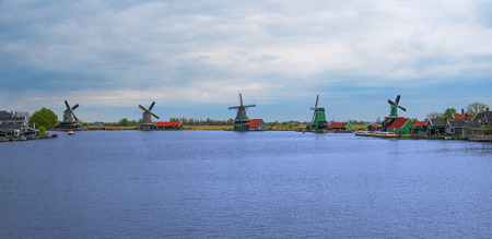 Panorama of Zaanse Schans windmills and water channel, North Holland, Netherlands, Europe. Panoramic view of dutch mills in famous authentic village, Zaan river. Row of old dutch traditional windmillsのeditorial素材