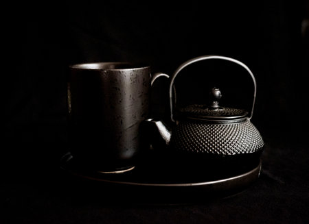 Tea set on a black background. Teapot and cup.の写真素材