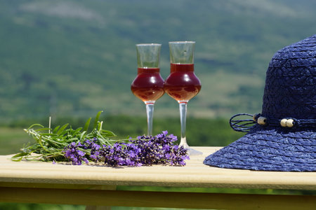 Two glasses of rose wine with lavender and hat on the tableの写真素材