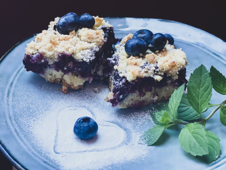 Blueberry crumble cake with fresh blueberries and mint on a plate.の写真素材