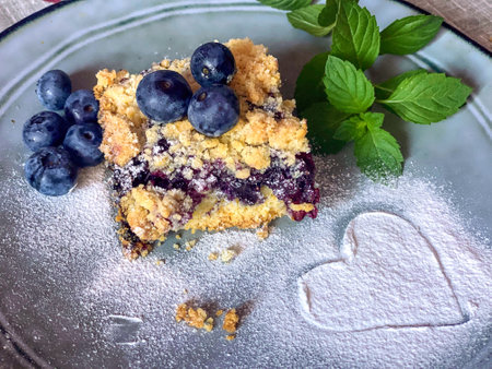 Crumble cake with blueberries and mint on a plate.の写真素材