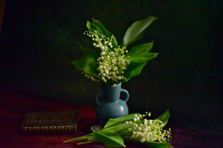 Lily of the valley in a blue vase on a dark backgroundの写真素材