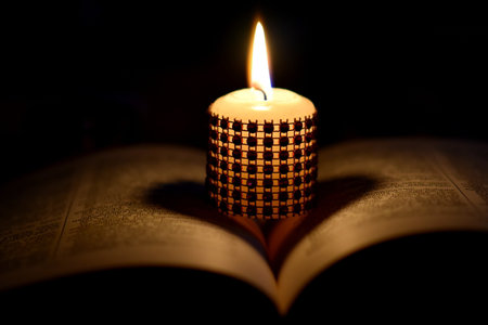 Burning candle on the old book. Shallow depth of fieldの写真素材