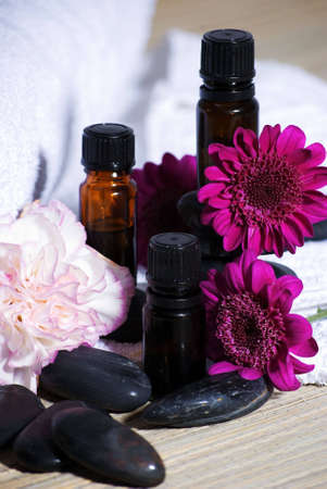 a vertical image of three essential oils and flowers の写真素材