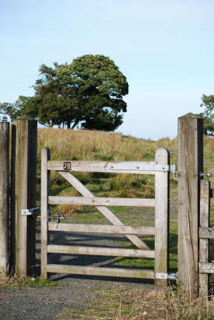  a vertical image of a wooden country gate leading onto a pathの写真素材