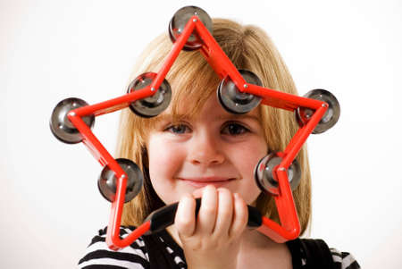 a horizontal image of a young female looking through a star shaped tambourineの写真素材