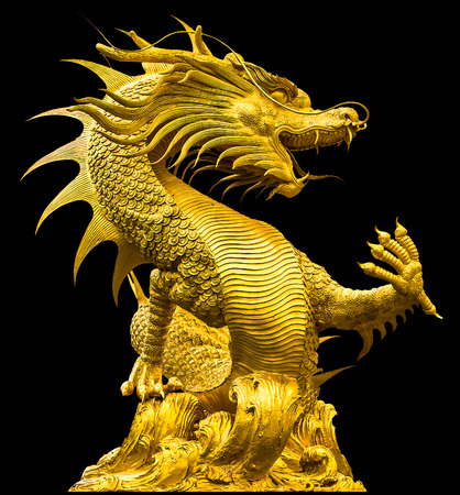 Golden dragon statue isolated on black backgroundの写真素材