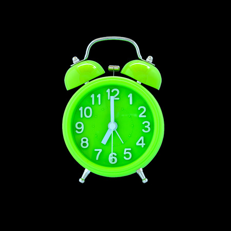 Green alarm clock isolated on black background