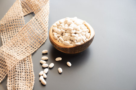 beans in wooden bowl and spoon on tableの写真素材
