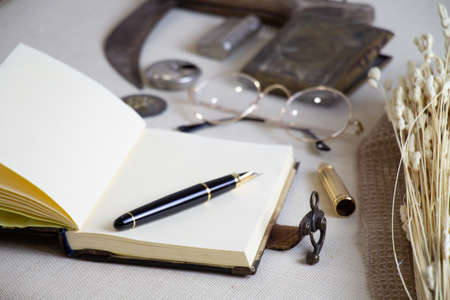notebook, pen and vintage accessories on the table