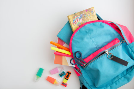 school supplies in school bag on white background
