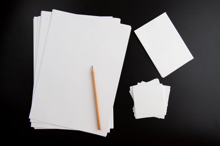 white papers and pencil on black backgroundの写真素材