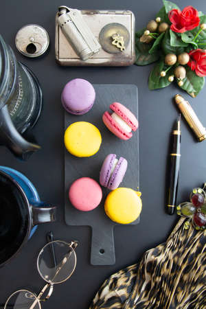coffee in cup, french press, macarons, accessories on black backgroundの写真素材