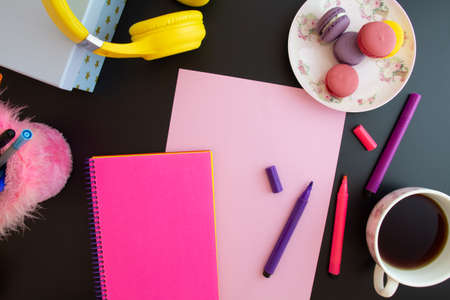 paper, notebook, colored pencils, macarons on a black backgroundの写真素材