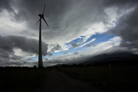 Wind turbine silhuette, with dark landscape background.の写真素材