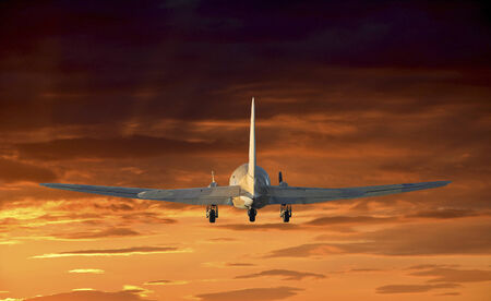 Flying old airplane with sunset background.