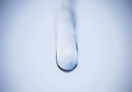 Soft blue droplet on a blue background.の写真素材