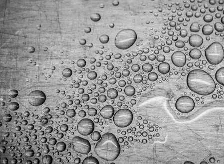 Water drops on a scratched metal surface.の写真素材