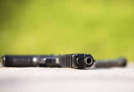 Front side of a gun with a blurred background.の写真素材