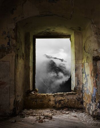 Old window in abandoned place with a mountain view.の写真素材