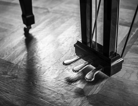 Dramatic piano foot pedals with soft reflection on a floor.の写真素材