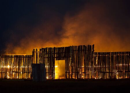 Wooden structure on fire with small sparks flying around.の写真素材