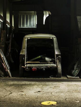 Old car waiting to be restored in a garage.の写真素材