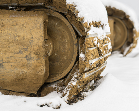 Heavy excavator steel tracks covered with some snow in winter time.の写真素材