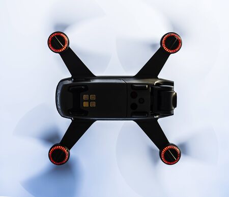 Small drone close up while flying above in the air.