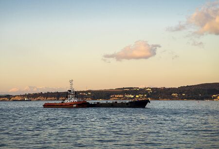 Tugboat is pushing another vessel on the sea.の写真素材