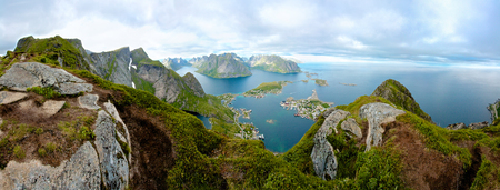 A panoramic view from the top of a cliff, overlooking small island towns connected by bridges. Shot above the arctic circle on Lofoten Island, Norwayの写真素材