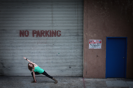 An urban Yogi meditates and practices outdoor yoga outside in the cityの写真素材
