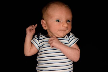 A 3 Week Old Baby Poses on a Black Background. Perfect for Memes with Copy Space.の写真素材