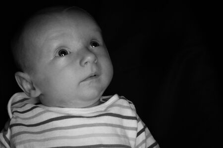 A 2 Month Old Baby Poses on a Black Background. Perfect for Memes with Copy Space.の写真素材