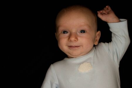 A Three Month Old Baby Poses on a Black Background. Perfect for Memes with Copy Space.の写真素材