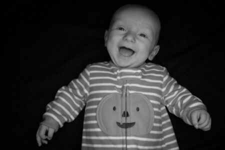 A Three Month Old Baby Poses on a Black Background. Perfect for Memes with Copy Space.の写真素材